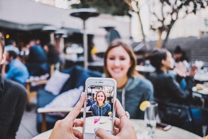 Devojka koja se fotografiše u kafiću